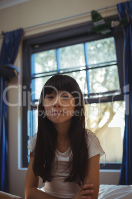 Smiling girl sitting on bed in the bed room