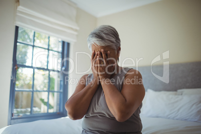 Senior woman covering her face at home