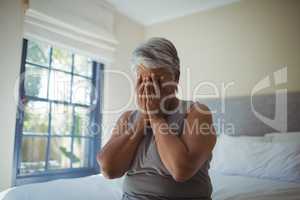 Senior woman covering her face at home