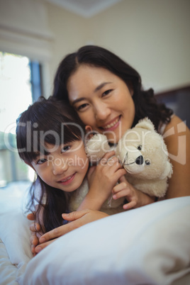 Mother and daughter relaxing on bed in bed room