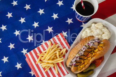 Hot dog served on plate with french fries and cold drink