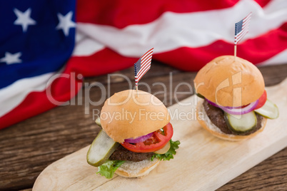 Burgers arranged on wooden board