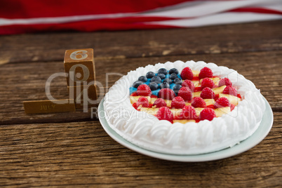 Date blocks and fruitcake on wooden table with 4th july theme