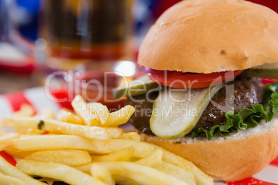 Burger and french fries on wooden table with 4th july theme