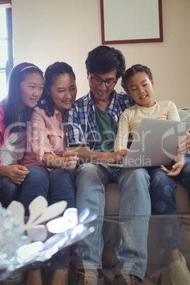 Family doing online shopping on laptop in living room