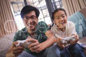 Father and daughter playing video game in living room