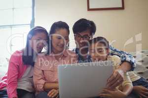 Family using laptop together in living room