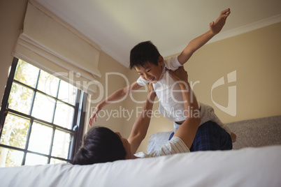 Father playing with his son in bedroom