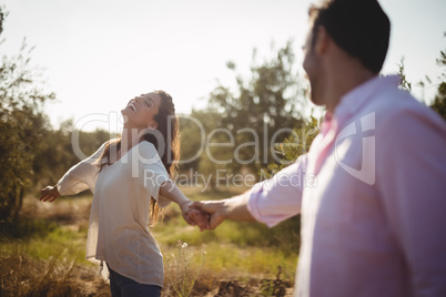 Cheerful young holding hands at olive farm