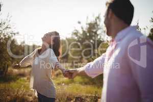 Cheerful young holding hands at olive farm