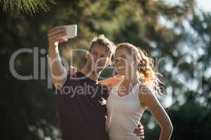Happy young couple taking selfie on sunny day at farm