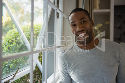Portrait of smiling man standing by window