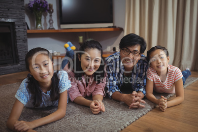 Smiling family relaxing on floor in living room