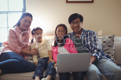 Family using laptop together in living room