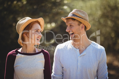 Cheerful young couple wearing hat on sunny day