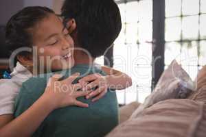 Happy father and daughter hugging each other in living room