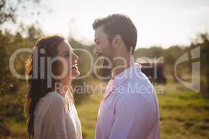 Happy young couple looking at each other at farm