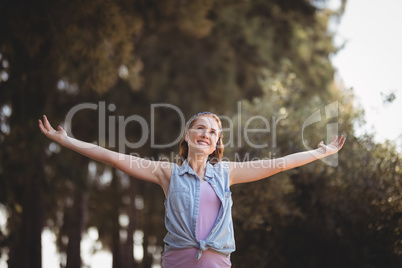 Beautiful young woman with arms outstretched at olive farm