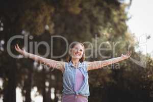 Beautiful young woman with arms outstretched at olive farm