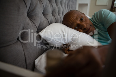 Portrait of senior man relaxing on bed