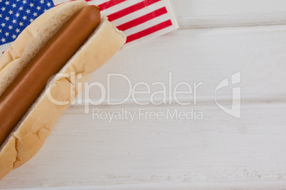 Hot dog and American flag on white wooden table