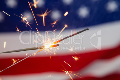 Sparklers burning against American flag background