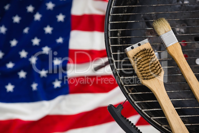 Basting brush arranged on barbeque against American flag