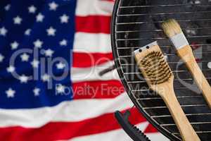 Basting brush arranged on barbeque against American flag