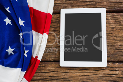 American flag and digital tablet arranged on wooden table