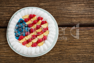 Fruitcake served in plate on wooden table