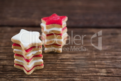 Red and white sugar cookies stacked on wooden table