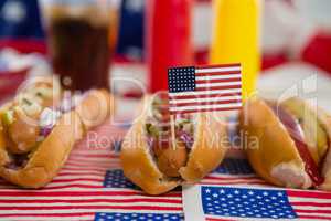 American flag and hot dogs on wooden table