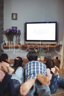 Family watching television together in living room