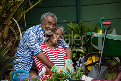 Portrait of happy senior couple embracing in backyard