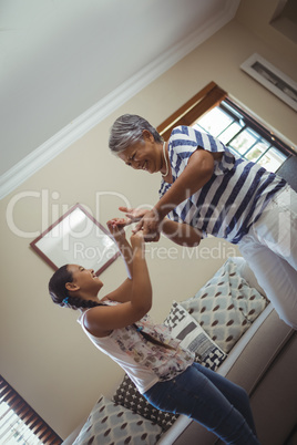 Grandmother and granddaughter having fun in living room