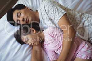 Father and daughter sleeping together in bedroom