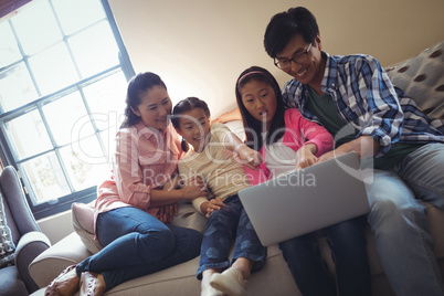 Family using laptop together in living room