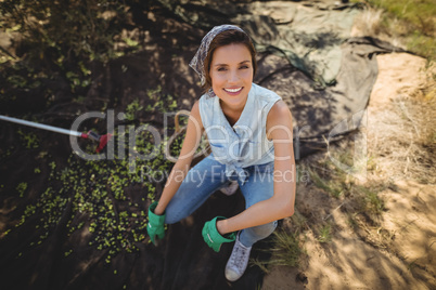 Portrait of smiling woman crouching on field at olive farm
