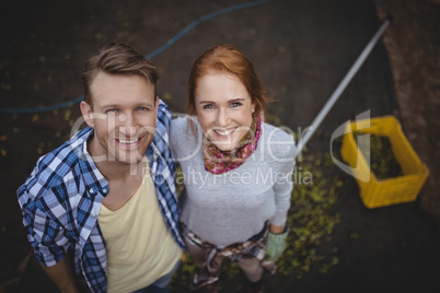 Portrait of happy young couple standing at olive farm