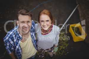Portrait of happy young couple standing at olive farm