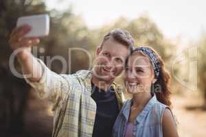 Cheerful young couple taking selfie at olive farm
