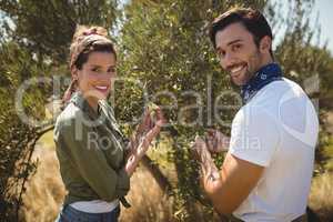 Smiling young couple holding olive tree at farm
