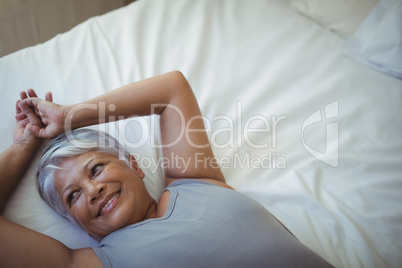 Senior woman relaxing on bed in bed room