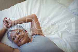 Senior woman relaxing on bed in bed room