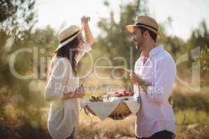 Happy young couple holding wicket basket at olive farm