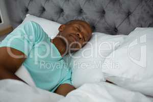Carefree senior man sleeping on bed