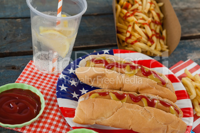 Hot dog served on plate with french fries