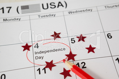 Red colored pencil with fourth of july calendar