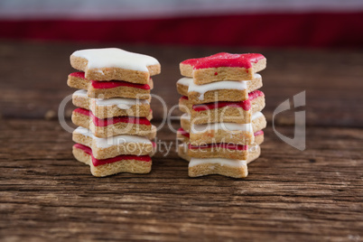 Red and white sugar cookies stacked on wooden table