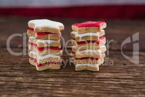 Red and white sugar cookies stacked on wooden table
